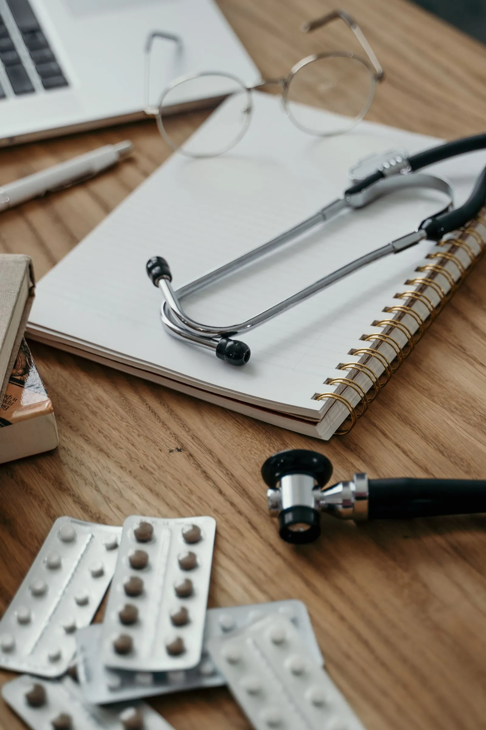 Stethoscope resting on a notebook used for writing patient health guides