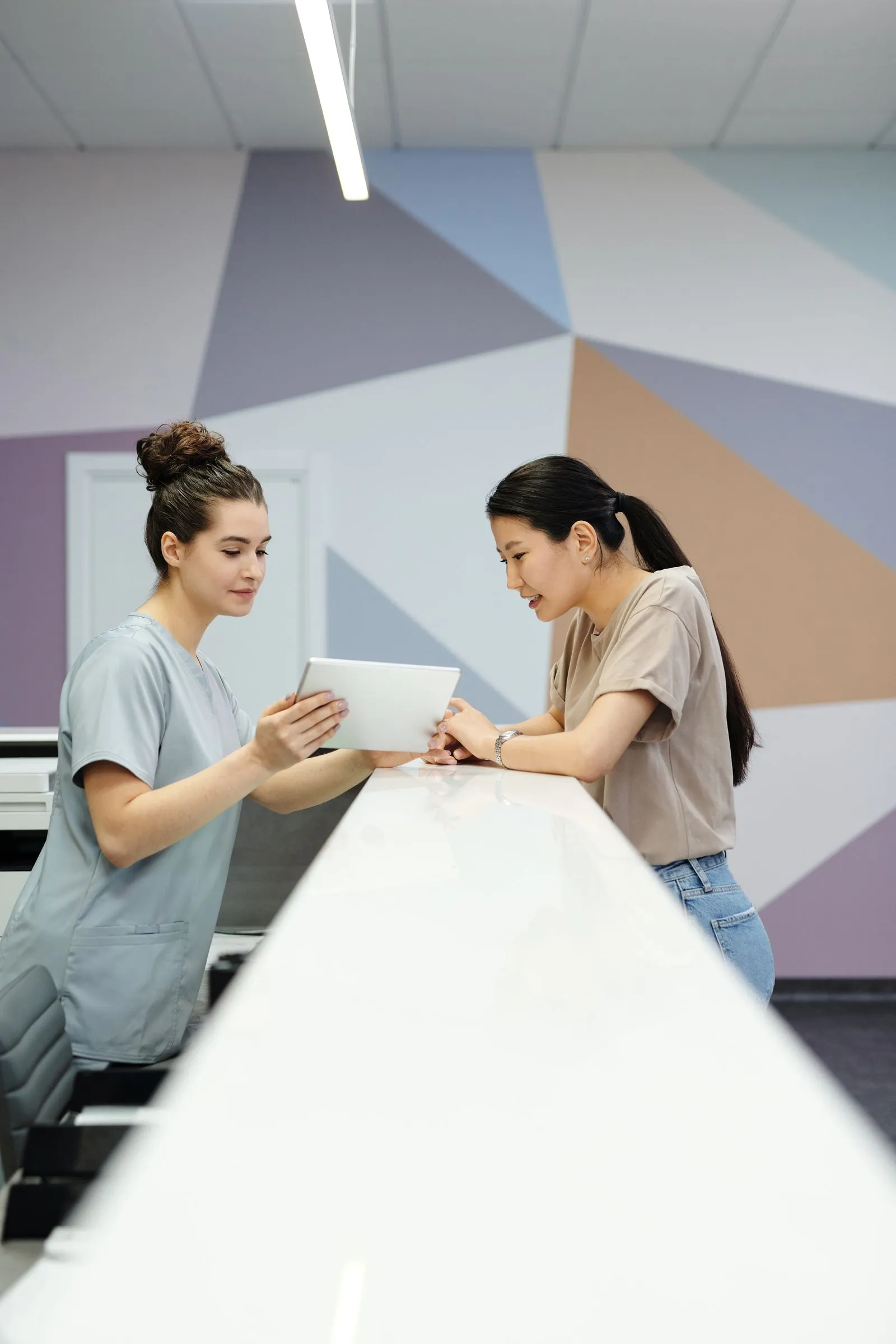 Front desk staff checking in a patient on a tablet