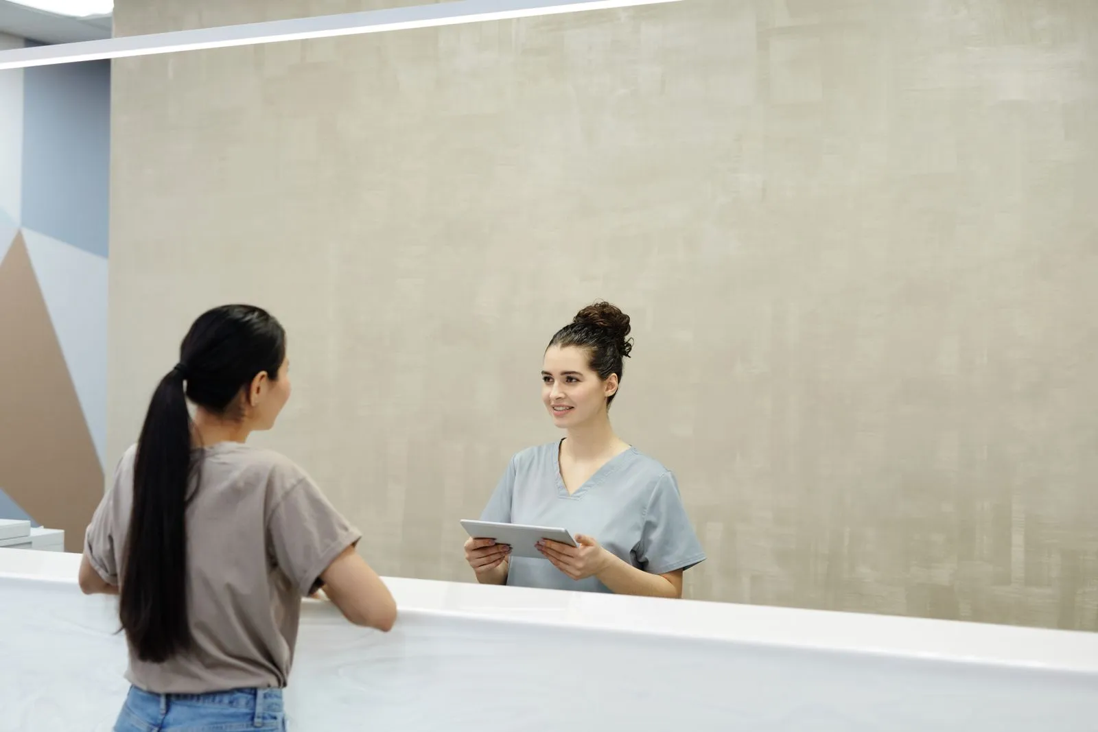 Receptionist greeting a patient at the front desk
