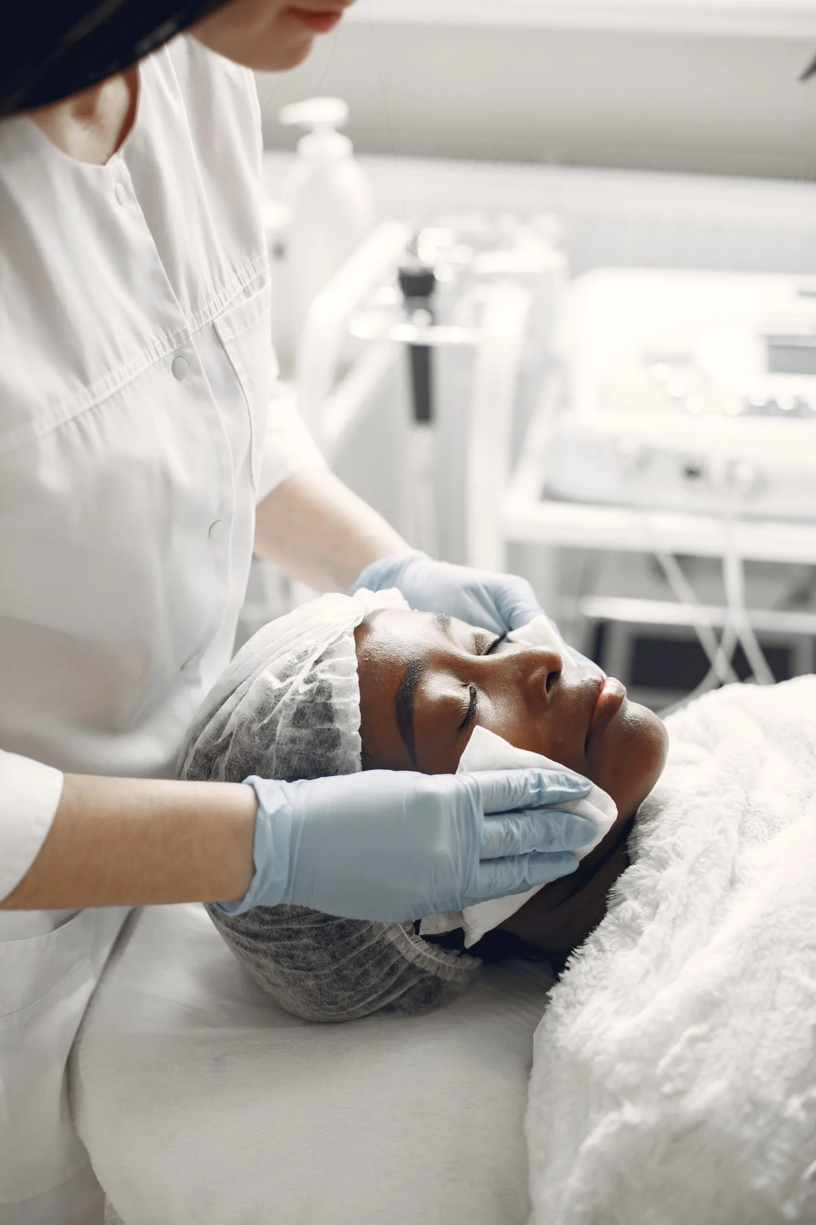 Clinician examining a patient’s facial skin