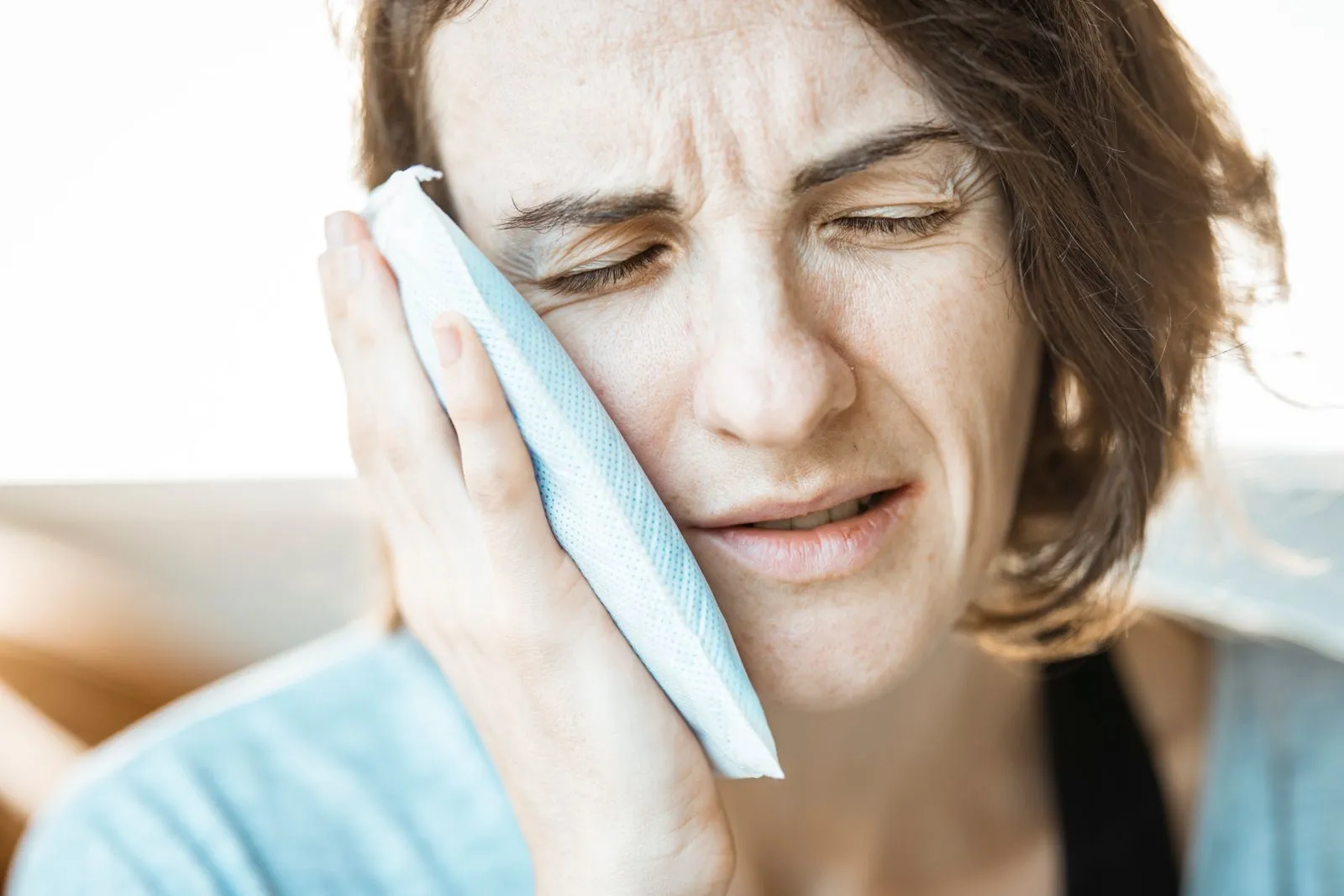 Woman holding a cold pack to her face for sinus pain