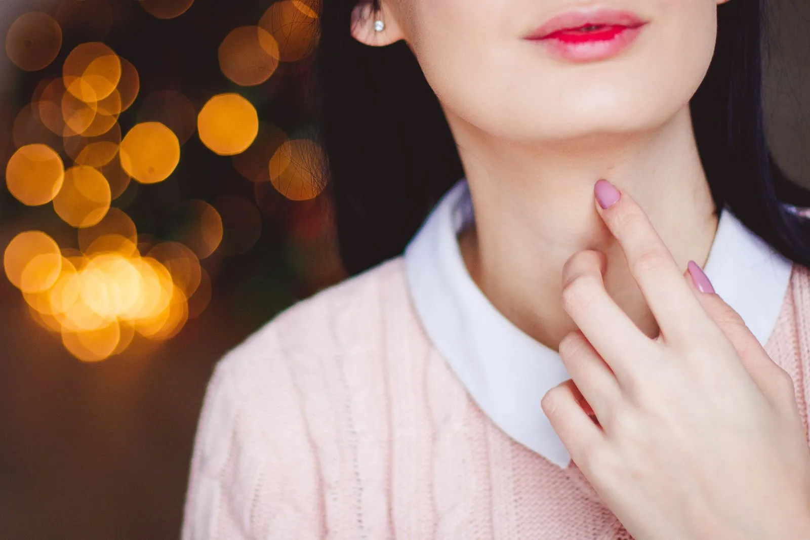 Woman holding her neck because of a sore throat