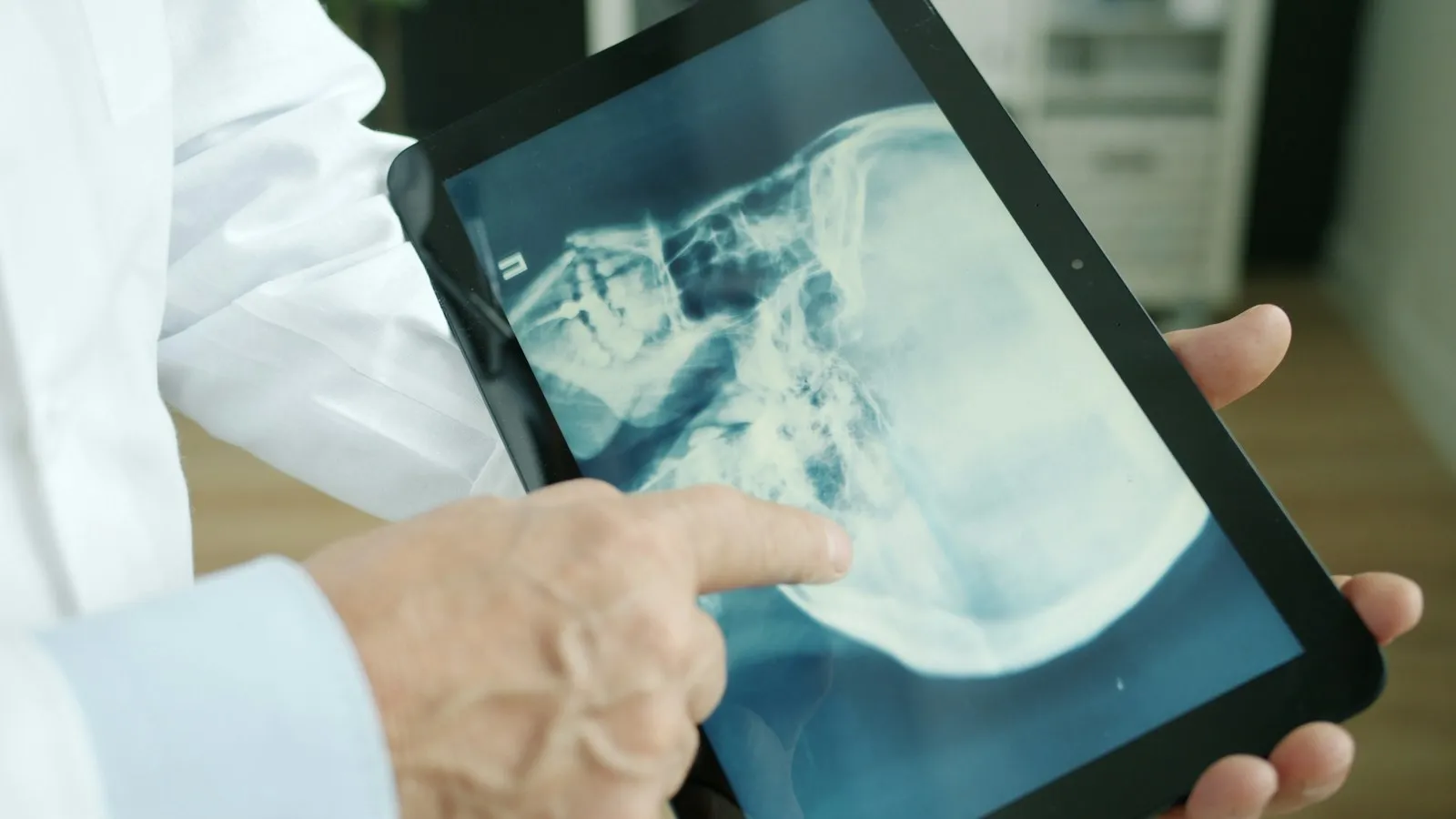 Doctor explaining an X-ray to a patient on a tablet